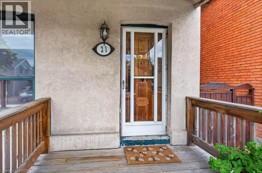 Front entrance featuring a glass-paned storm door, a classic exterior wall lantern, and a decorative address plaque
