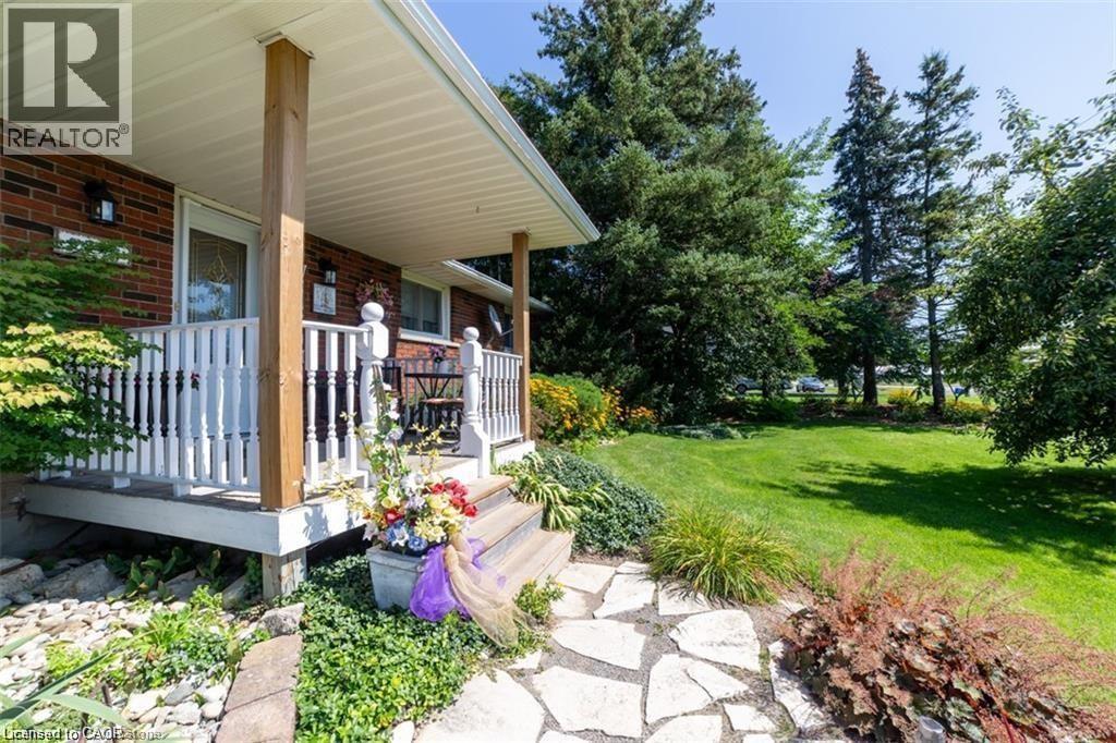 Front porch with white railings, natural wood columns, and brick exterior
