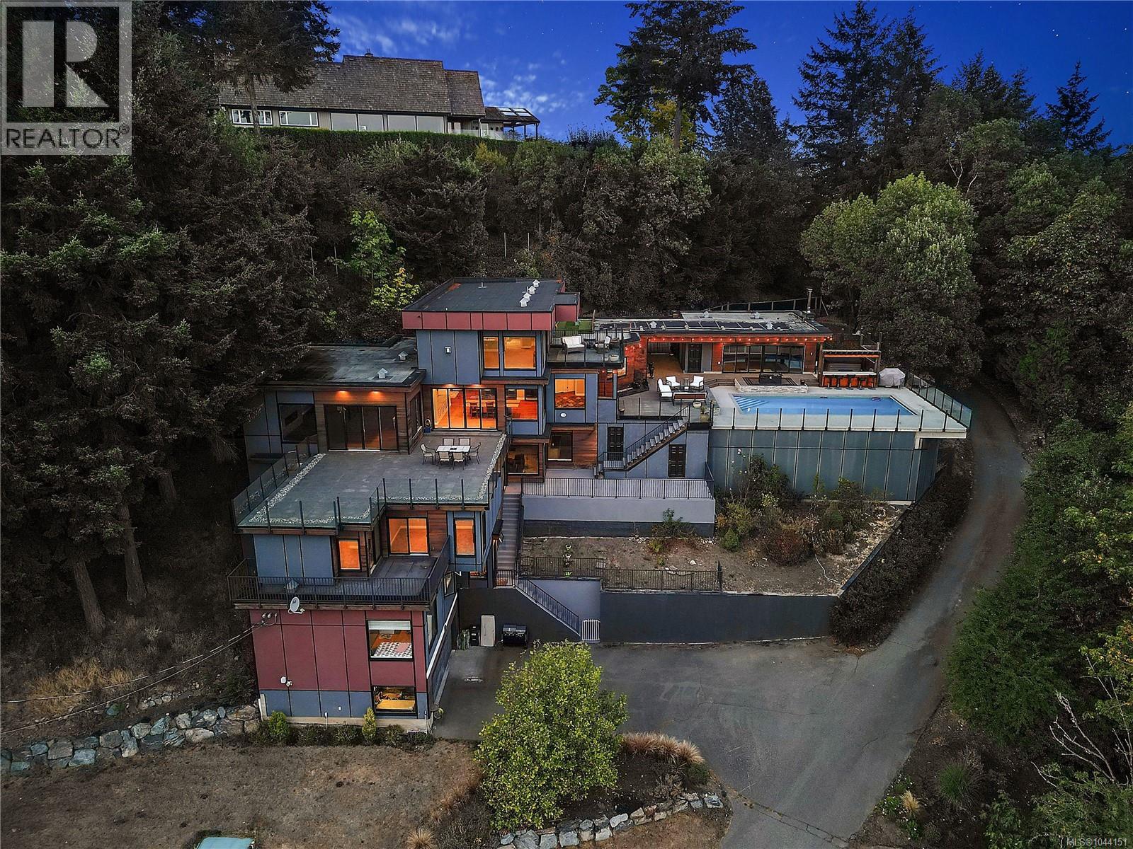 Striking contemporary residence showcases impressive architecture, multiple terraces, and beautifully landscaped grounds.