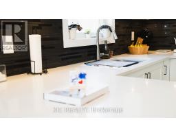 Modern kitchen with quartz countertops, dark subway tile backsplash, and stainless steel faucet - 352 Appalachian Circle Ottawa