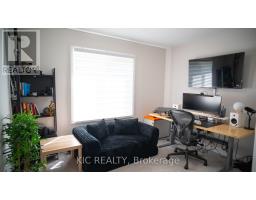 Home office with desk, computer, large monitor, TV, sofa, and bookshelf - 352 Appalachian Circle Ottawa