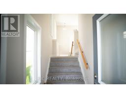 Carpeted stairs with wooden handrail, large window, interior door - 352 Appalachian Circle Ottawa