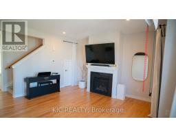 Living room with fireplace, TV, piano, mirror, and hardwood floors - 352 Appalachian Circle Ottawa