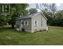 Light green house with metal roof, AC unit, and propane tank - 2956 County Road 14 Stone Mills