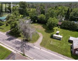 Property with shipping container, driveway, and trees - 2956 County Road 14 Stone Mills