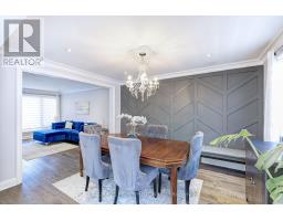 Dining room with tufted chairs, crystal chandelier, and geometric wall - 109 Woodcroft Lane Vaughan