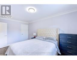 Bedroom with tufted headboard, dark blue dresser, and white duvet - 109 Woodcroft Lane Vaughan