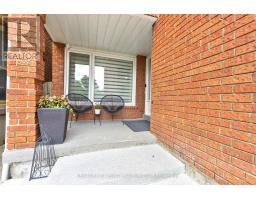 Front porch with brick exterior, modern chairs, and flowers - 109 Woodcroft Lane Vaughan