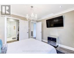 Bedroom with crystal chandelier, wall-mounted TV, mirrored nightstand, and ensuite bathroom - 109 Woodcroft Lane Vaughan