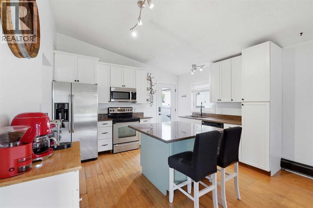 The kitchen features white cabinetry, stainless steel appliances and granite countertops