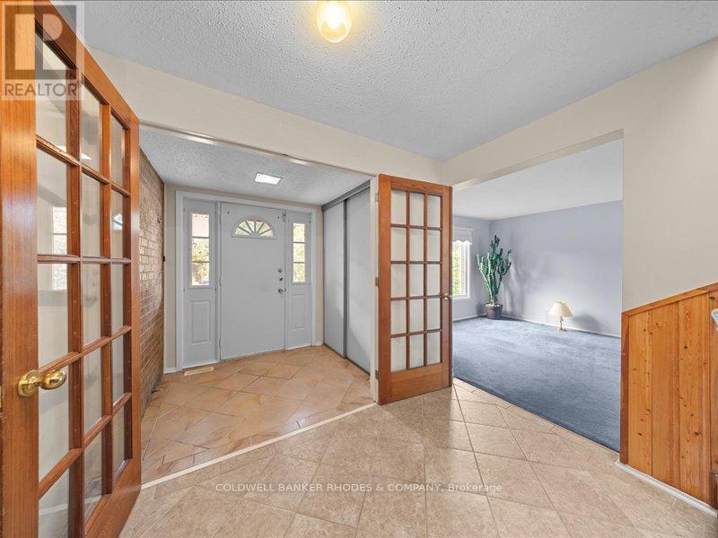 Foyer with exposed brick wall and French doors
