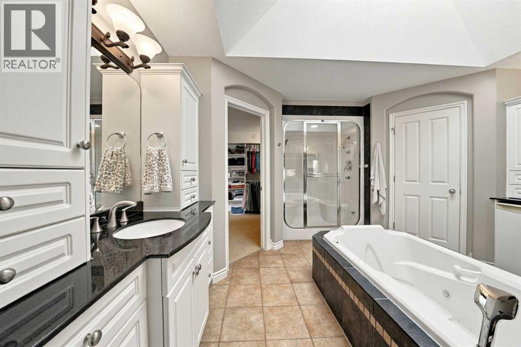 The primary 5-piece ensuite features separate vanities, a centre soaker tub underneath a skylight, a steam shower, and access to the large walk-in closet