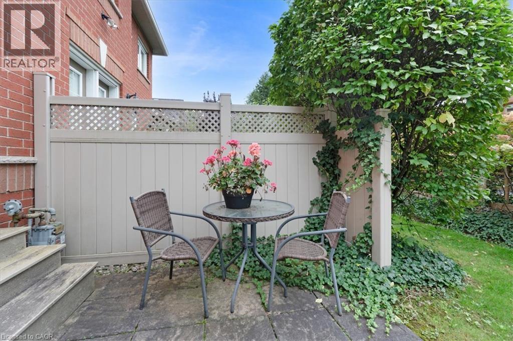 Paved patio area featuring a privacy fence with lattice detail, brick exterior, and a manicured lawn