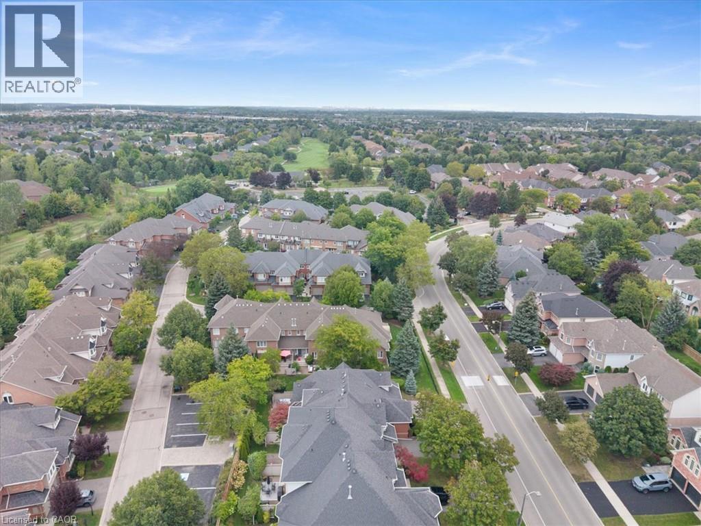 Expansive neighborhood showcasing detached homes and townhomes, mature trees, and a golf course