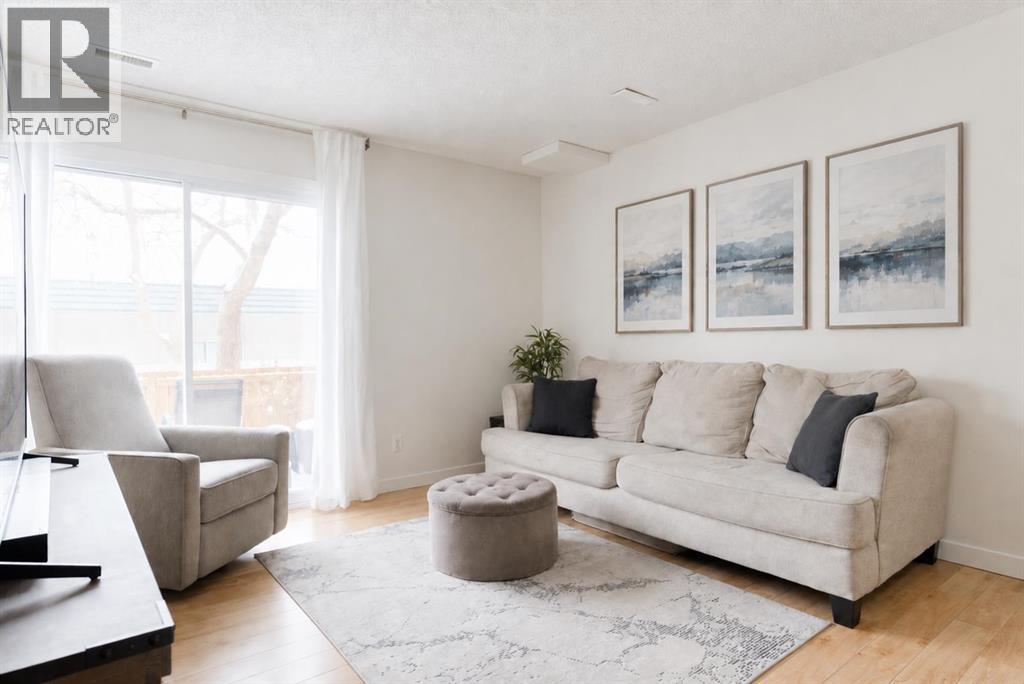 Bright living room with large windows and patio access (artwork digitally added)