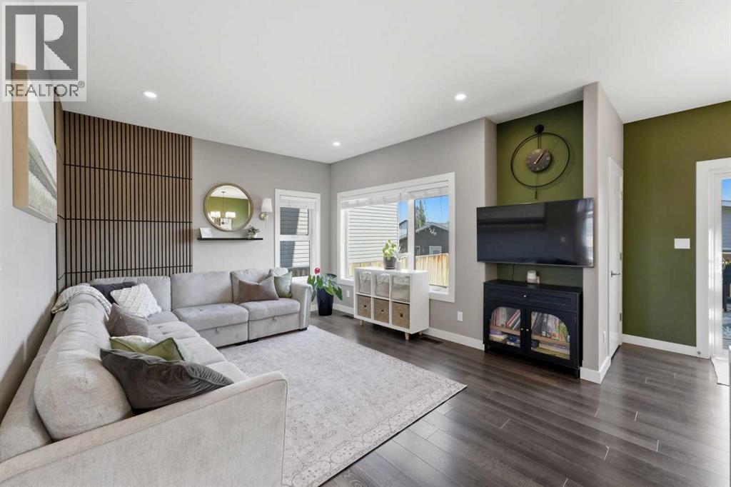 The living room is highlighted by a stylish wood feature wall