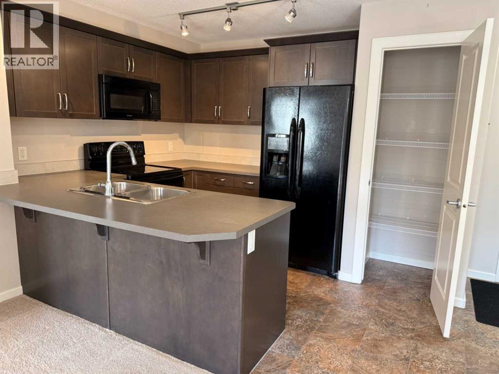 Gourmet Kitchen with warm maple cabinetry and sleek black appliances and Pantry