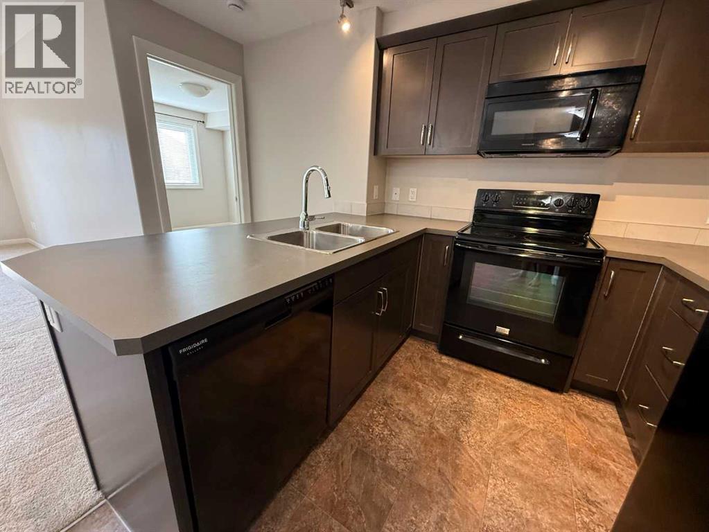 Gourmet Kitchen with warm maple cabinetry and sleek black appliances