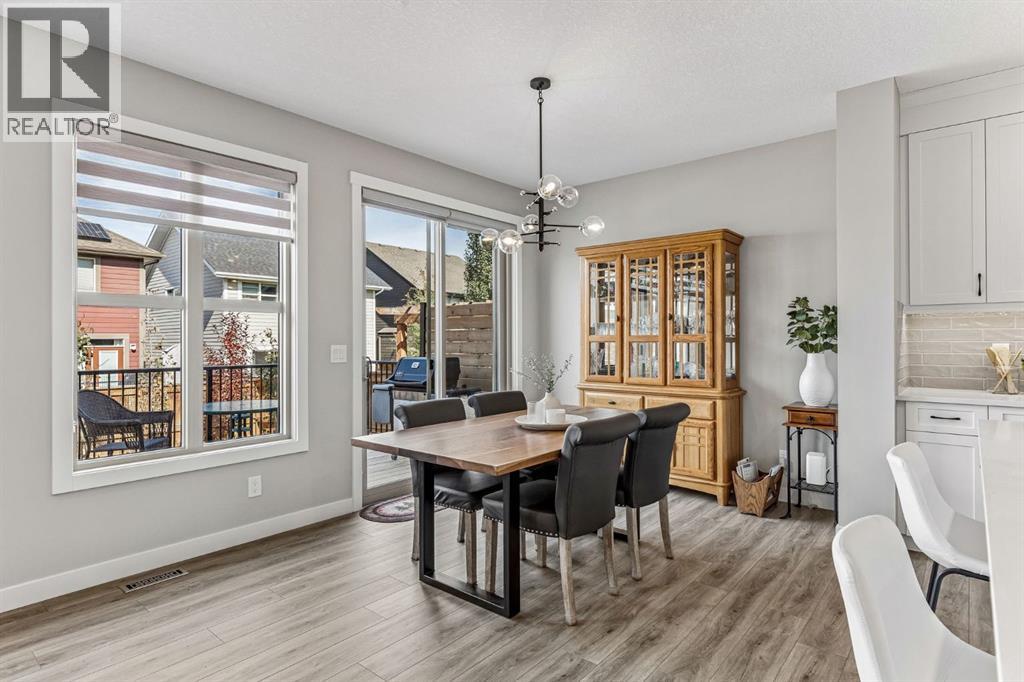 Surrounded by large windows and patio doors, the dining space is filled with natural light and offers an inviting setting for everything from weeknight dinners to weekend gatherings