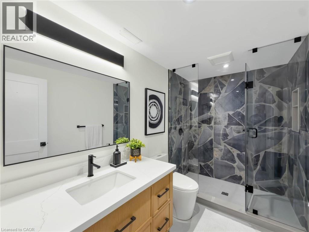 Walk-in shower with frameless glass enclosure and mosaic-patterned tile