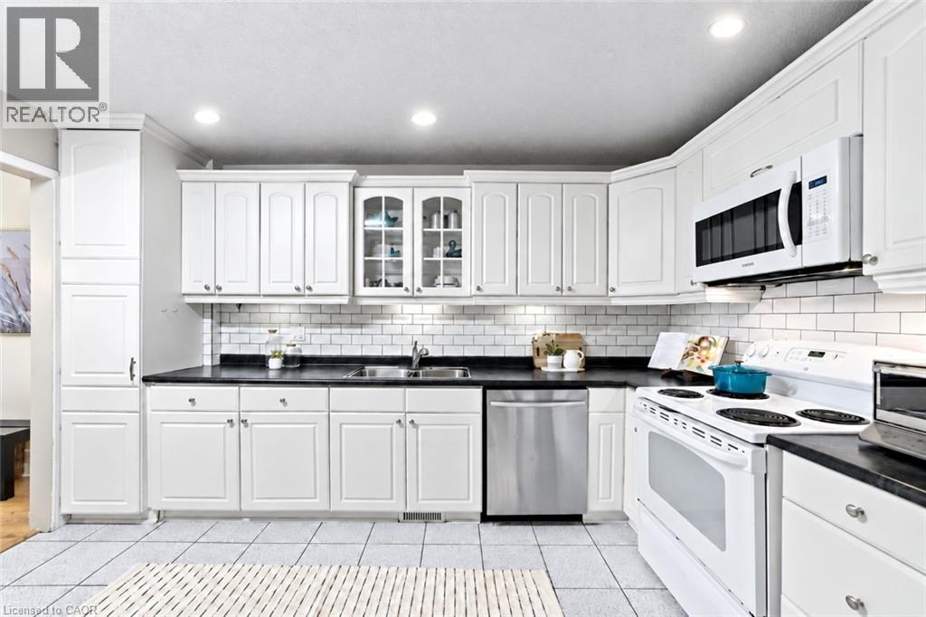 White cabinetry and dark countertops complemented by a subway tile backsplash