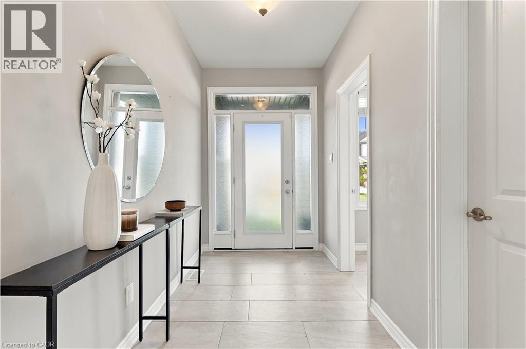 Entryway featuring a front door with sidelights and transom window, light-toned floor tiling, and a recessed ceiling light fixture