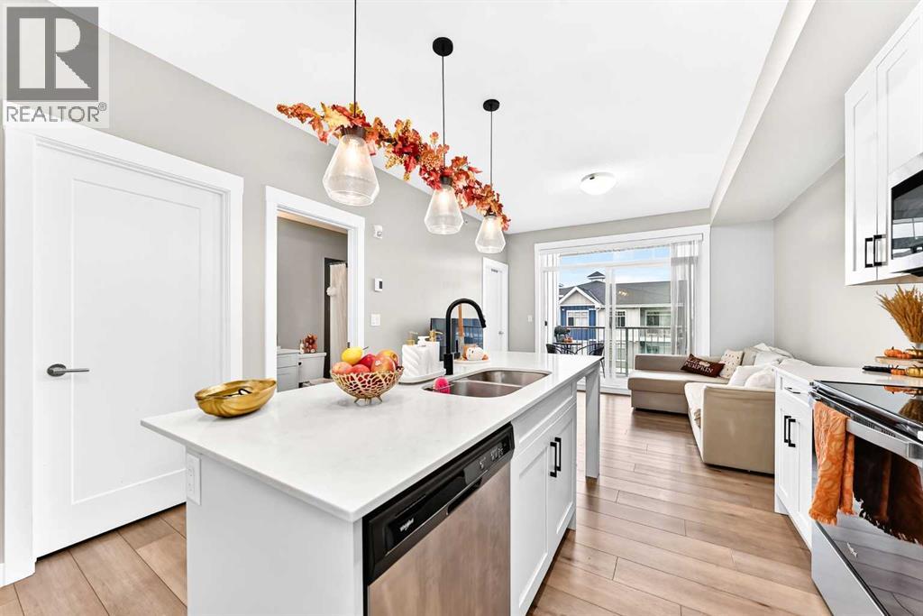 Open-concept view from the kitchen toward the living area, with a spacious island and access to the balcony