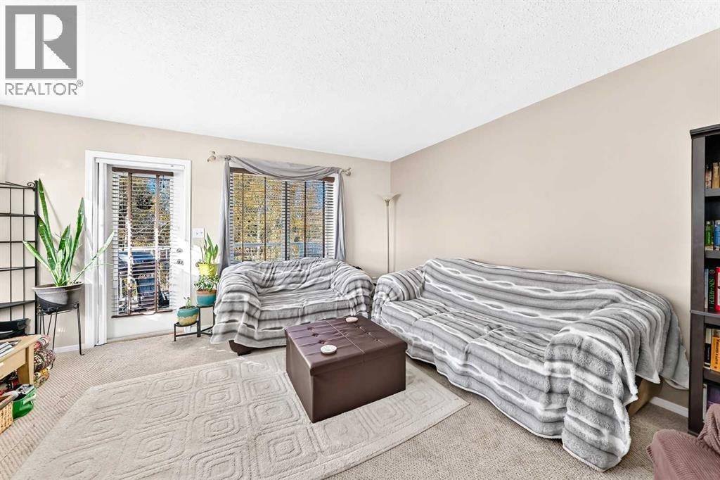 Good sized livingroom with door to the deck looking out to the treed area
