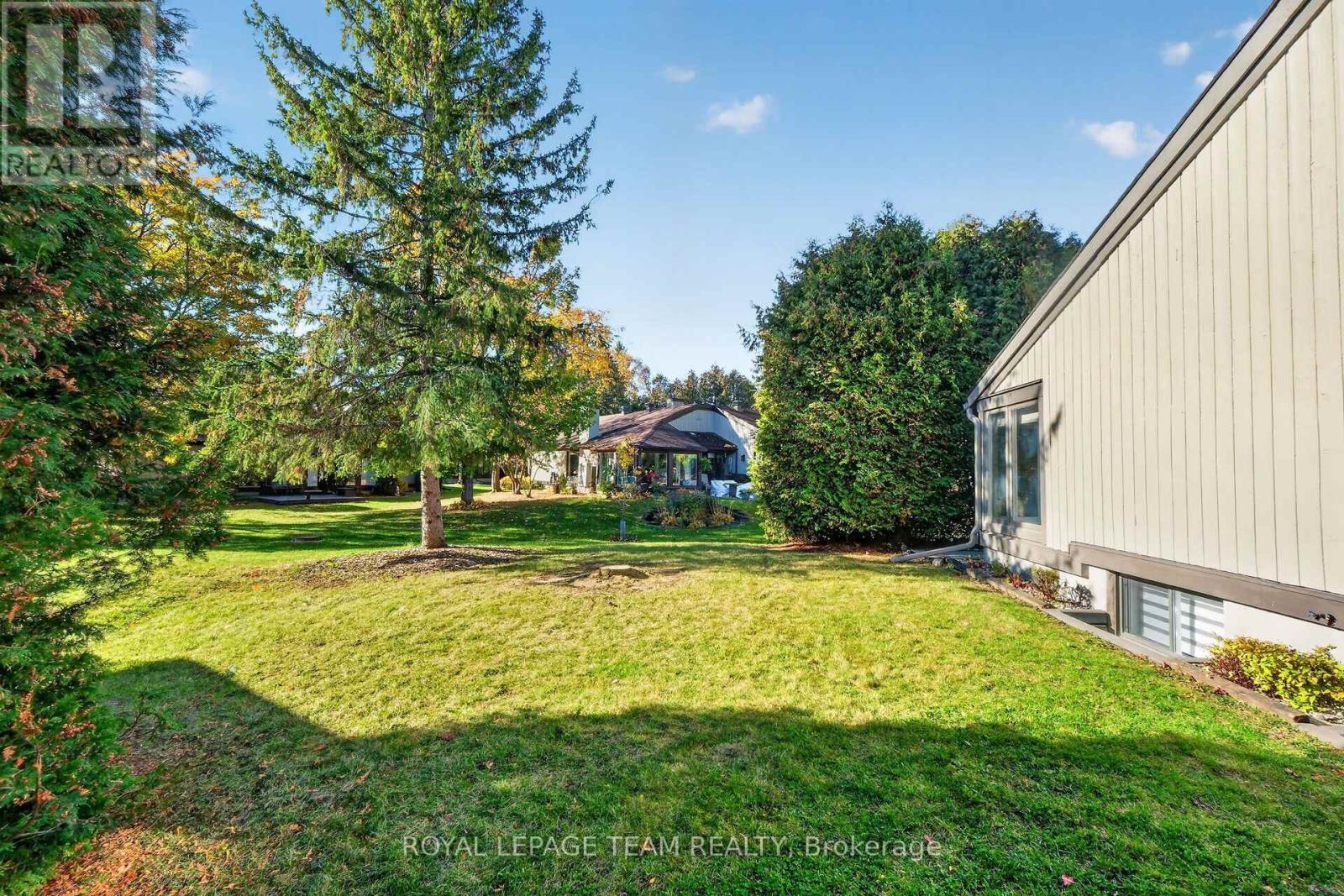 End unit home surrounded by mature trees & hedges.