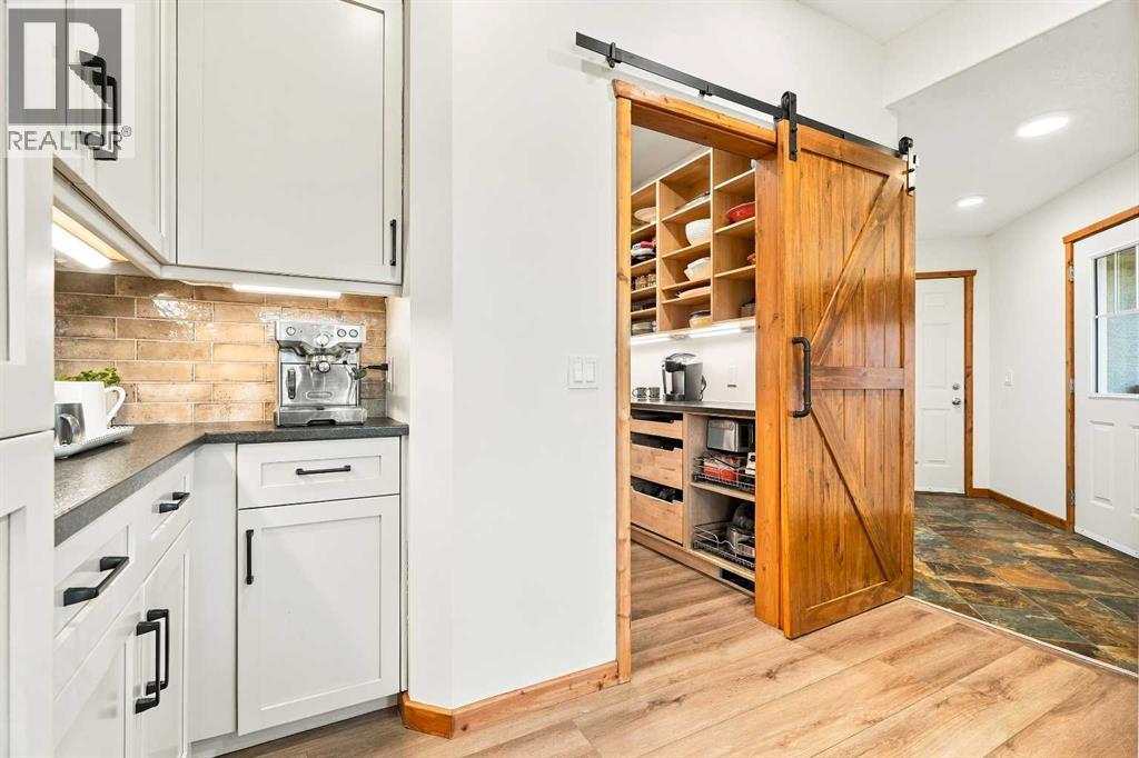 The pantry with sliding custom wood door offers loads of storage room
