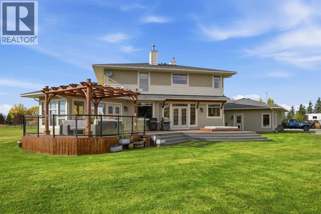The rear of the home features a massive deck with pergula and hot tub, accessible through two double door options from dining room and from sun room