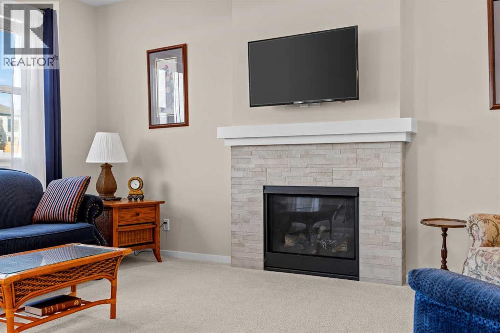 A stone surround and white mantle anchor the living room