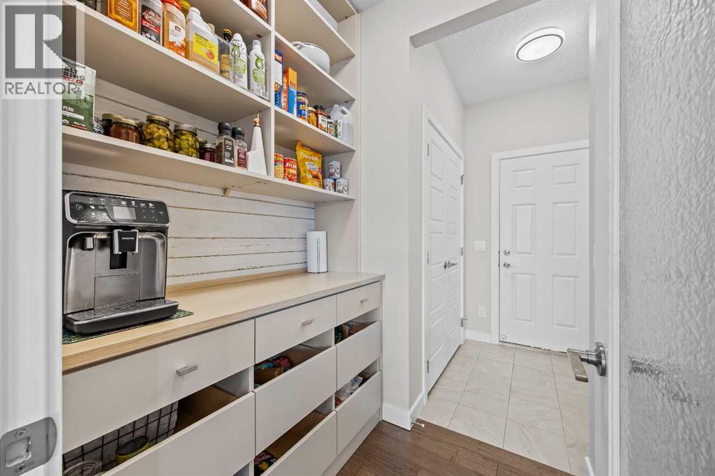 From small appliances to pantry essentials, everything has its place here, with custom drawers, open shelving, and a convenient connection to the mudroom and garage