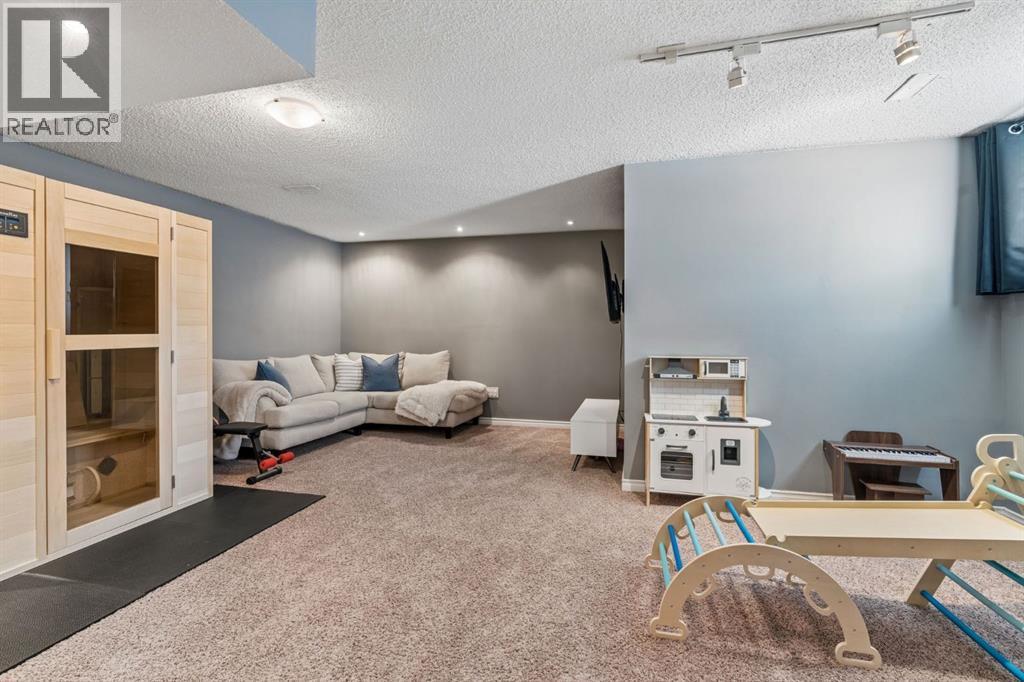 The fully developed basement offers an inviting extension of the home's living space, featuring a cozy lounge area, home sauna & plenty of room for recreation, relaxation & family activities