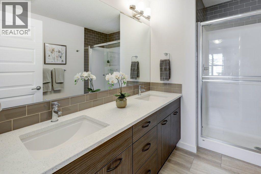 All bathroom vanities match the kitchen cabinetry and countertops, creating a cohesive, high-end look throughout
