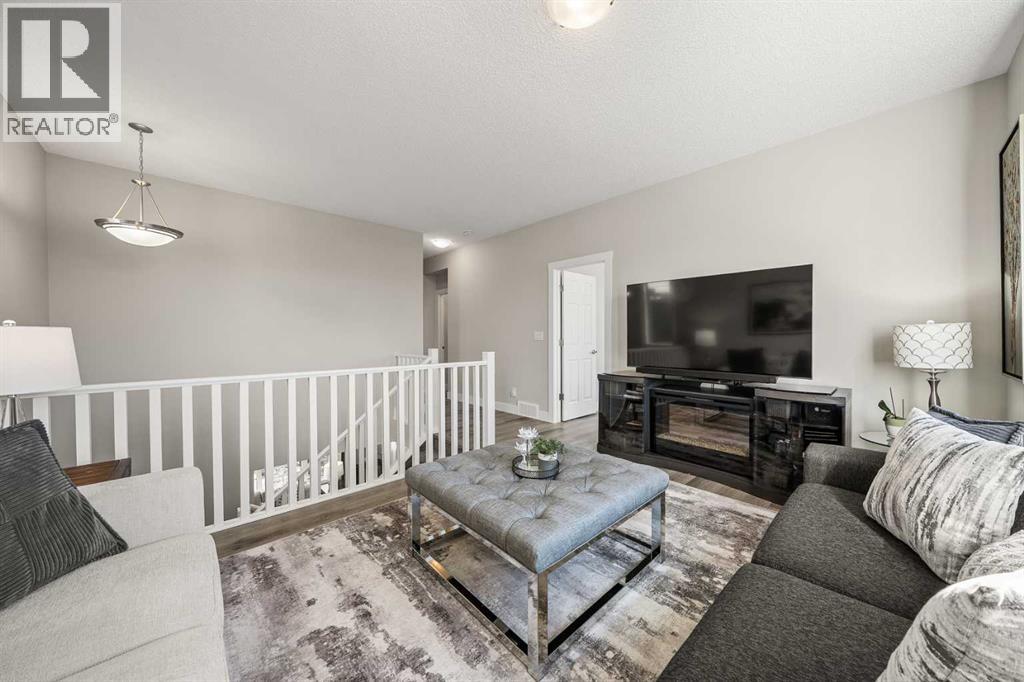 Versatile upper-level family room with comfortable seating and open stairway views