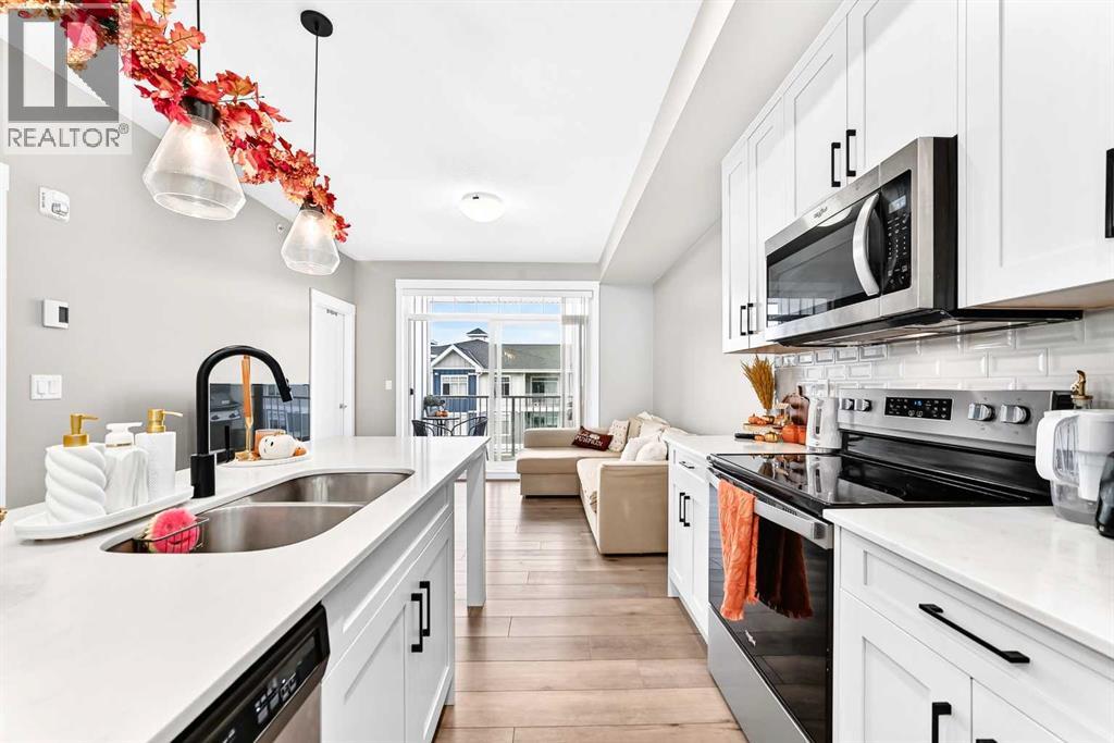 Spacious Kitchen with stainless steel appliances, ample counter space, and a large island overlooking the living area