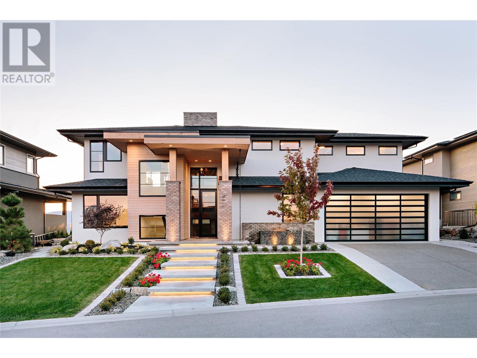 1462 Rocky Point Drive Kelowna, British Columbia A unique opportunity in the prestigious Wilden neighbourhood, this custom built 2019 show home of the year from award winning builder Fawdry Homes will take your breath away w/sweeping 180 degree views of the Okanagan Lake + mountains. Truly designed for entertaining, this 4 bedroom + den modern home offers an open main flr plan w/2 stories of great room windows framing the amazing views opening into the covered patio area merging into the meticulously maintained low maintenance rear yard. Main flor features inc: a large kitchen w/over-sized Wolf gas range, panel Sub-Zero fridge/freezer, pantry/mudroom w/tons of storage, wet bar w/beverage fridge, 2 storey linear gas fireplace, spacious great room, 3 piece bath + office/future bedroom. Upper flr offers a lg primary suite w/built-in custom bed, his/her walk-in closet, a spacious ensuite w/lg soaker tub + curbless tiled shower, left style TV area, wet bar, 1/2 bath + the lg covered deck to soak in the sweeping views. Bsmt offers 2 full bedrooms, a 3 piece bathroom, wet bar/kitchen area however with the open design + lg windows, the potential for additional bedrooms. Basement also offers a separate grade to basement level entrance which would all for a possible suite. Other features include a 3 car garage, advanced heating/cooling system, underground sprinklers, solar panel system, full central vacuum w/hidden hose attachments + full security/camera system. Full New Home Warranty inlcuded. Potential for a pool. (id:48254)