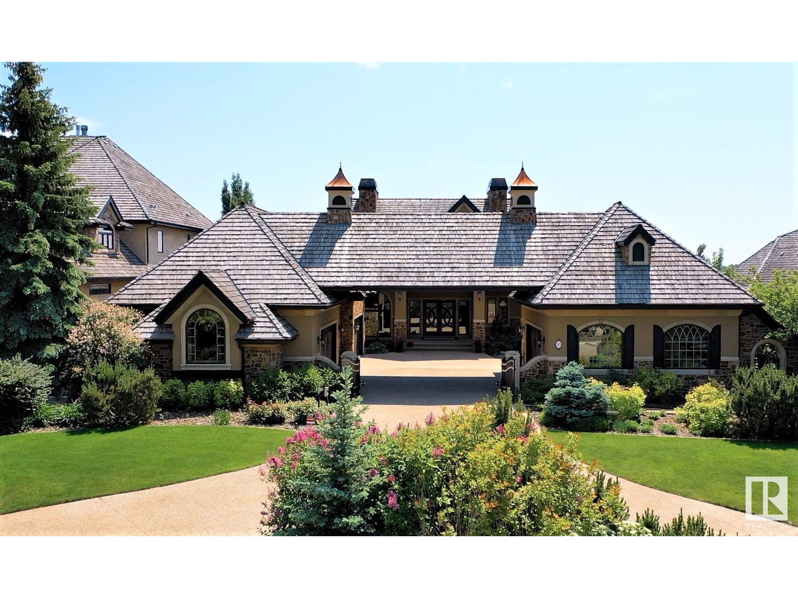 This STUNNING, Audie Benson Estate Homes show home is the grandest of the grand! 7100 sq ft of luxury living on 0.72 acres of gorgeous river valley views in prestigious Riverstone Pointe, minutes out of St. Albert & to the Anthony Henday. The curb appeal is unsurpassed with drive through portico, natural iron stone, copper chimneys & capolas & iron security gate. Step across the threshold into an elegant foyer w/views of the Great Room, boasting 20' open vaulted cherry ceilings, an exquisite formal dining room & music room, wall-to-wall & floor to ceiling library complete with sliding ladder. The den is perfectly situated off the luxurious master suite & library. This magnificent walkout bungalow boasts awards for best kitchen & best ensuite in North America. Main floor access to the south backing upper patio, with views of double waterfalls, bridges & rose gardens. The lower level includes a gathering room, games room, theatre, old world wine cellar, fitness room w/massage area, and SO MUCH MORE! (id:48254)