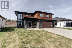 Absolutely stunning two-storey home in a prime South End neighborhood, conveniently located near top-rated schools. This bright, immaculate, architecturally designed home features a grand foyer that opens to a main-level den with full-height, double-storey windows, custom solar-powered window shades, and a remarkable great room—perfect for those who love to entertain, offering the ultimate wow factor. The phenomenal kitchen boasts a breakfast bar, ultra-modern cabinetry, high-end appliances, and quartz countertops, complemented by beautiful hardwood flooring throughout the entire home. At the back, wall-to-wall windows and double patio doors lead to your private backyard oasis, complete with a brand-new interlocking courtyard,  a pergola, and a hot tub (2024). The impressive upper level features a family room overlooking the foyer, a primary suite with built-ins, breathtaking views, and an oversized ensuite with a custom glass shower. Additional highlights include exquisite custom tile work in the bathrooms, in-floor heating throughout the main level, a custom two-year-old shed, and a modern interlocking driveway that enhances the home’s striking curb appeal with its sleek design. Freshly painted, in mint condition, and move-in ready—this home truly shows like a dream! (id:48254)