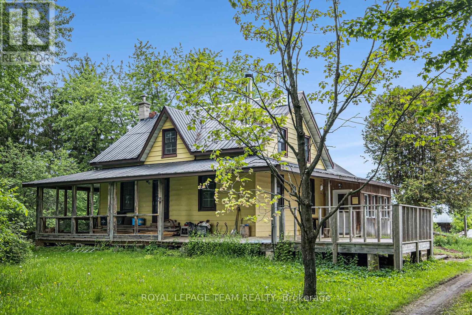 Tucked away in total privacy, this spectacular 147-acre property is a rare find for those seeking tranquility, space, and a deep connection to nature. Surrounded by mature forest and offering approximately 20 acres of open, workable fields, the possibilities here are endless, whether you're dreaming of a hobby farm, or a peaceful family retreat. The charming 2-storey home radiates rustic warmth, with a main floor that captures the essence of a cozy log cabin. Rich wood finishes, exposed beam ceilings, and two wood-burning fireplaces create an inviting atmosphere throughout. The open-concept kitchen and dining area is perfect for family gatherings, with direct access to a screened-in porch. The living room features hardwood floors and a second fireplace, ideal for curling up on cool evenings. A front den with hardwood flooring adds flexible space for an office, library, or quiet reading room. Upstairs, the newly carpeted family room offers additional space to relax or entertain. Two comfortable bedrooms and a 3-piece bath with soaker tub round out the second floor--all freshly painted! A standout feature of the property is the impressive 85' x 54' storage building, providing plenty of room for equipment, recreational toys, workshop space, or creative projects.  Both wood burning stoves are WETT certified. Bell Fibe is the current provider. Furnace 2022.  Reverse osmosis and ultra violet systems installed for exceptional water quality.  Double garage with 200 amp panel.  Just a short 10 minute drive to the historic village of Merrickville and all it's amenities. (id:48254)