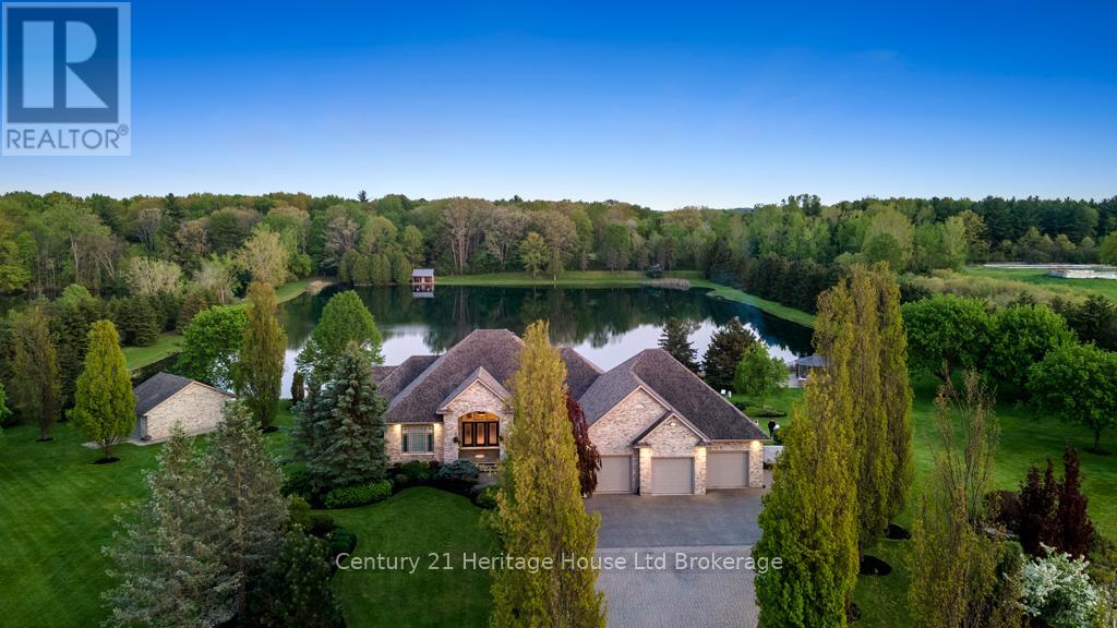 5067 Hamilton Road Thames Centre, Ontario Welcome to this exquisite 8.8 acre estate in Dorchester. 2 severed building lots out front of estate are not included in this price but can be bought in addition. Experience 'The Muskoka's' 15 min. from the City of London & Airport. Immerse yourself in the opulence of lakeside and forest views, felt through every expansive southern window. You will be captivated by the grand back staircase, covered upper deck, & lower covered porch. Indulge in relaxation with a hot tub overlooking the professionally landscaped grounds. Delight in your very own 4.5acre stocked lake with vibrant koi, trout, & perch. 2 docks w bubblers for boating, fishing, & swimming. Amenities incl. a 24x20 workshop/garage w heat and bay door, 18x12 storage shed/bunkie/boathouse w bay door, a 16 ft. 3-season Gazebo, & firepit area with BBQ. Easy 14-zone irrigation and fertigation system. The 1500 sq. ft. 3-car garage featuring in-floor heating, a 2 pc bath, Custom workbenches and cabinets with full size fridge & freezer, epoxy floors, and 80" TV, is nothing short of awesome. A Sonas Surround system, intercom system, 5-camera alarm system, & 4 garage door openers provide comfort and security. The concrete driveway, walkway, and front porch are heated, with interlocking finishing the remaining part of the drive. The lower level features an extravagant custom maple bar with quartz countertops, colour changing glass shelving, and 5 high-quality appliances. Boasting 4 bedrooms and 5 bathrooms, in-floor heating throughout the main house, a traditional gas furnace, and central air, this estate is the pinnacle of comfort. The master suite & luxurious ensuite bathroom provide a sanctuary for rejuvenation. Additional highlights include a large formal dining room, a massive kitchen with an island & bistro area, & 2 laundry rooms. An elegant living room with walnut hardwood, a double-sided fireplace, crown moulding, & arches overlooks the serene private lake. (id:48254)