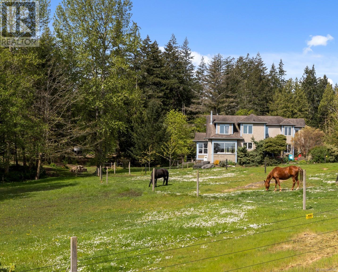 2035 Pace Road Nanaimo, British Columbia Welcome to nearly 5 acres of natural beauty, ocean vistas, and west coast lifestyle just north of Boat Harbour. Tucked away at the end of a quiet no-thru road, this architect-designed estate offers a peaceful retreat with beach access only a short stroll away. Enjoy kayaking, coastal walks, and watching local wildlife—otters, seals, sea lions, and even the occasional passing orca pod. The property is a harmonious mix of open meadows and mature forest, with fir, cedar, oak, and maple trees, a seasonal creek, and about 2 acres of wooded land. A deer-fenced orchard is planted with fruit trees, herbs, and raised garden beds, perfect for a self-sufficient lifestyle. Horse lovers will appreciate the 70x100 riding ring, lunging area, and a custom 40x24 three-stall barn with power, water, and a heated tack/tool room. Electric cross-fencing surrounds the property, which also includes a pump house and two sheds for additional storage. Inside, the home exudes rustic elegance with wide plank pine floors, wood-sashed thermal windows, and a stunning stone fireplace. A sunroom with a wood-burning cookstove adds a cozy character, while large windows overlook the ocean-facing pastures, and a west-facing cedar deck enhances the indoor-outdoor connection. The flexible layout offers 4–5 bedrooms, 3 bathrooms, 2 kitchens, and 2 laundry areas, including a private-entry in-law suite with its own deck. The suite can be easily reconnected to the main home if desired. Efficient systems include an electric forced air heat pump, A/C, HRV, and backup electric heat. Water comes from a 150-ft well to a 1600-gallon cistern, supplemented by a 1200-gallon rainwater collection system with sand filtration and UV purification. This is a rare opportunity to enjoy coastal serenity, multi-functional land, and well-planned infrastructure, just minutes from town. A one-of-a-kind property with heart, history, and space to grow. (id:48254)