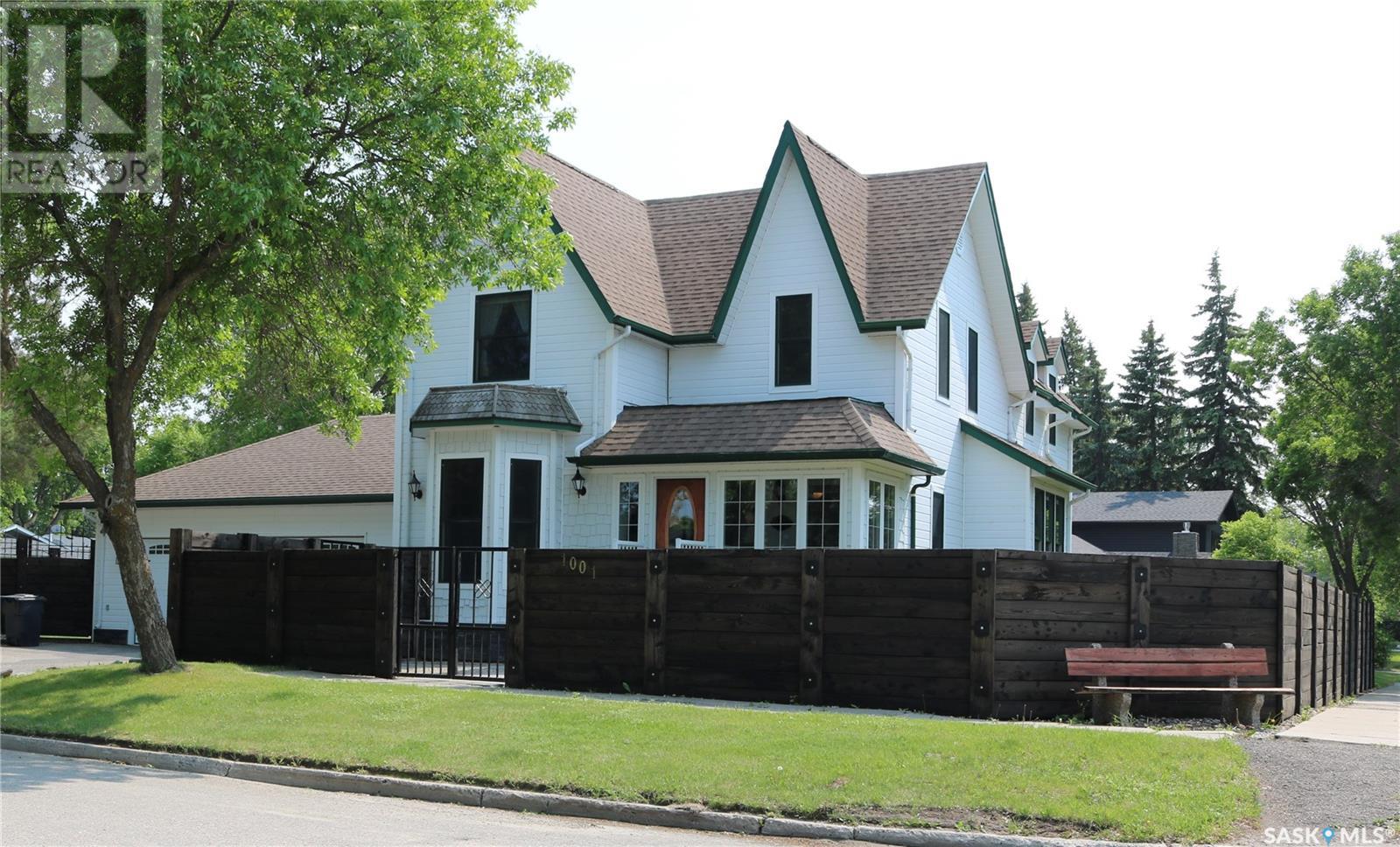 1001 Mark Avenue Moosomin, Saskatchewan This magnificent home is a designated Heritage Property. The house was moved off and a new concrete foundation poured in 1998. Extensive renovations followed, right back to the studs, but it still maintains the original charm and character. Sturdy wood fence with metal details and gates offers the utmost privacy and safety for your yard. Enter in and you're warmly welcomed by the charming entrance - a sunny porch. A sitting area follows, with an ideal home office with bay window to your left. From there, the living room is next, then a family room (or formal dining area if you wish) with large windows. So much light floods this home! The eat in kitchen is spacious and has lots of cabinet space, and island and a large pantry. Off to the back entrance with double doors out to the patio and backyard, or use the other door to take you out to the heated, oversized garage. There is also a handy two piece bath back here. Up the gorgeous oak staircase to the primary bedroom with 3 piece ensuite and a second large bedroom. Down a short hallway to the third bedroom and huge three piece bah with beautiful soaker tub. Next to the bathroom is a bright sunroom that is home to the laundry. A unique feature is a dumbwaiter that can be accessed from this room to the mud room below. The basement has a separate entrance from the garage, as well as stairs from the main part of the home. It is well set up and can be used as a one bedroom rental option if you wish. Large entrance at the bottom of the stairs with a place for coats and access to the utility room. One large bedroom, a gorgeous three piece bath with converted antique vanity and tiled shower. Large space for an office or living room as well as a kitchen. Let's not forget about the yard! Beautifully landscaped with manicured lawn, raised beds and garden space, two Chestnut trees, and a large shed. The fence has two large gates for easy access. The patio is where you will want to spend your entire summer! Let's go for a tour! (id:48254)