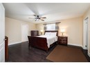 Bedroom with dark wood-style floors, a ceiling fan, and a textured ceiling