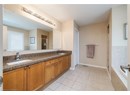 Full bath featuring a shower stall, double vanity, tile patterned floors, and tiled tub