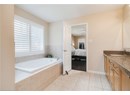 Ensuite bathroom with a bath, vanity, and tile patterned floors