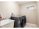 Laundry area with independent washer and dryer and light tile patterned flooring