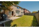 Back of property with brick siding, a fenced backyard, and a patio