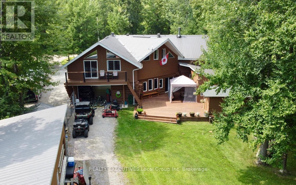 Experience the ultimate in waterfront living with this impressive log home on the shores of Lake Nipissing. The open-concept main level features a soaring vaulted ceiling over the living room, large windows  and sliding glass door looks out to the water.  A warm slab-on-grade foundation with efficient in-floor heating keeps the house warm along with a wood stove providing cozy ambiance.  Upstairs offers three large bedrooms plus a generous recreational room, providing space for family and guests alike. The primary bedroom has a deck, that offers views out over the lake.  A 24' x 45' attached garage also with in-floor heating offers incredible versatility, complete with drive-through doors for backyard access and a full 3-piece bath. Outdoors, the property is designed for year-round enjoyment, featuring a spacious back deck with a covered BBQ area, a dedicated hot tub building, and a full-sized sauna. For additional storage, there is a detached garage for recreational equipment or workshop space. At the waters edge, you will find a greenhouse, a pavilion overlooking the lake, a private boat launch, and a U-shaped dock with deep water suitable for larger boats. The natural break wall offers excellent protection, allowing you to keep your boat in the water all summer. This rare offering combines the craftsmanship of a log home with exceptional waterfront amenities, making it an ideal retreat for both relaxation and adventure. No taxes for lease land. (id:48254)